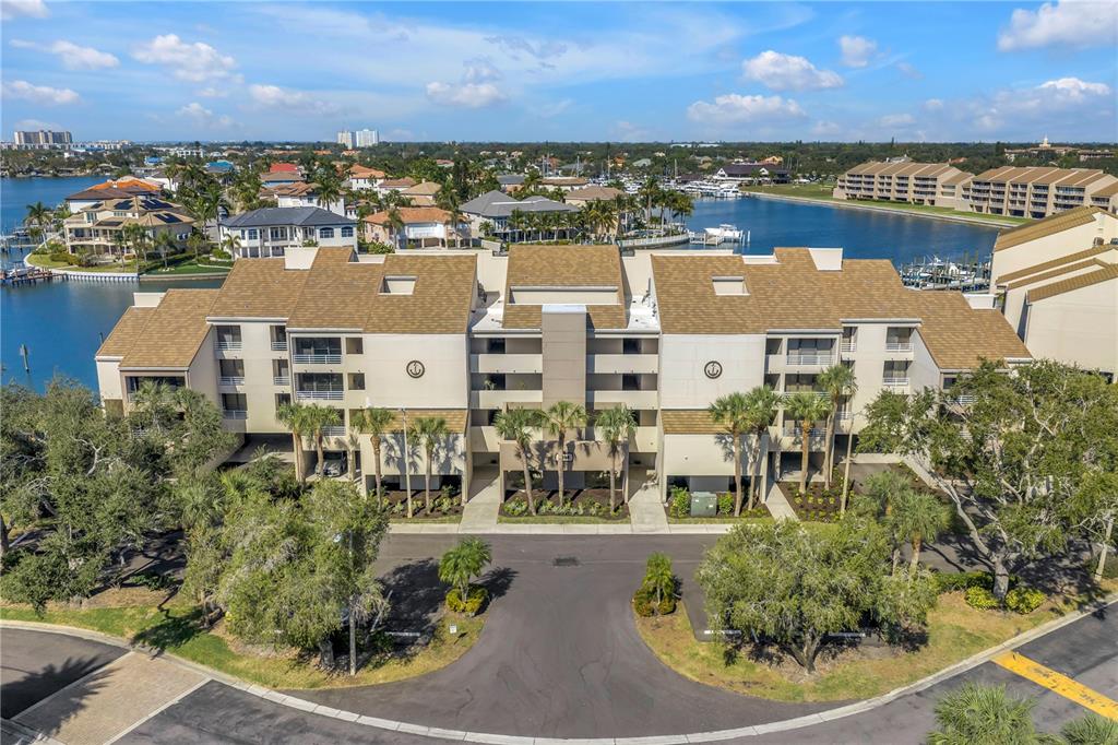 An aerial view of a multi-story apartment building with a parking lot and waterfront — 2795 KIPPS COLONY DRIVE S UNIT 305, ST PETERSBURG, FL
