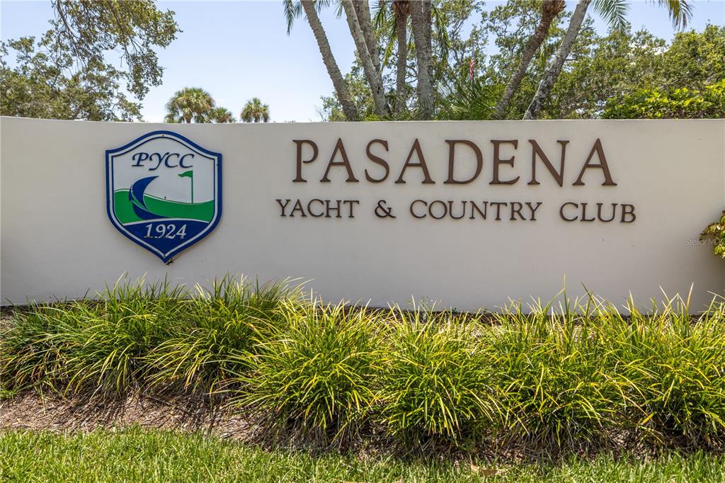 A sign for the Pasadena Yacht & Country Club stands in front of green landscaping — 2795 KIPPS COLONY DRIVE S UNIT 305, ST PETERSBURG, FL