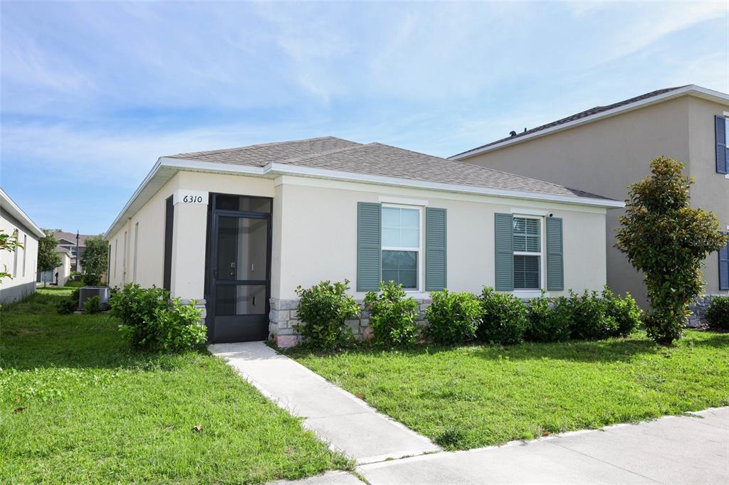 A single-story house with a beige exterior, green shutters, and a screened front entryway — 6310 CANTER CIRCLE, APOPKA, FL
