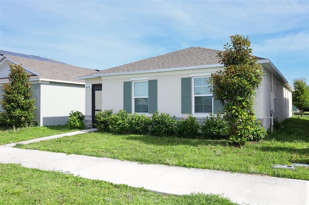 A single-story house with a light-colored exterior, green shutters, and a front lawn — 6310 CANTER CIRCLE, APOPKA, FL