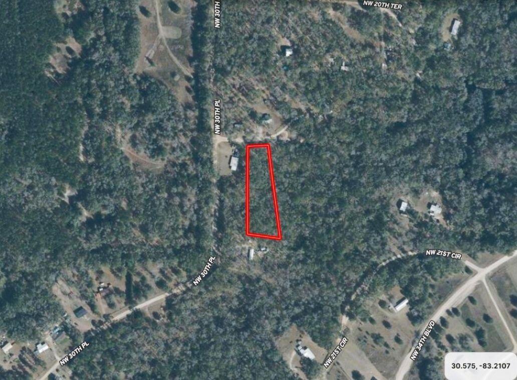 An aerial map view shows a rectangular plot of land outlined in red among trees — Lot 26 NW White Oak Way, FL 32053, FL