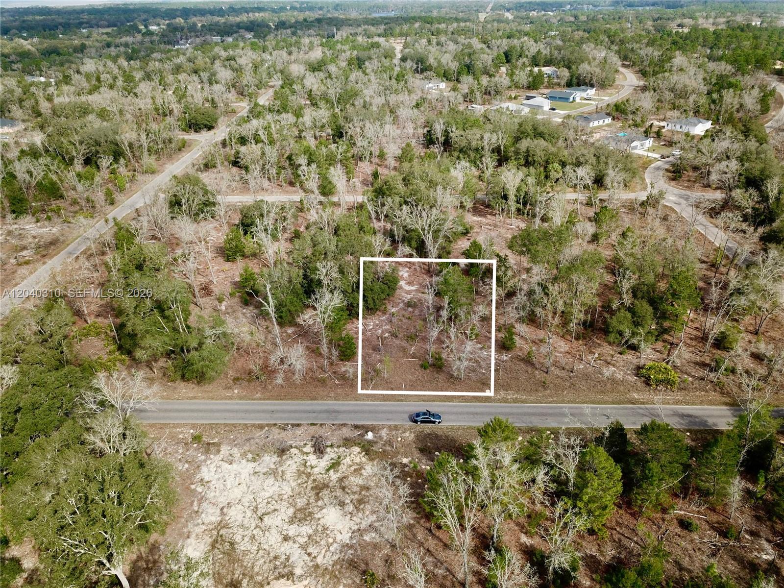 An aerial view shows a rectangular plot of land outlined in white beside a road — Lot Nearby 19 Bay Track Court, Other City - In The State Of Florida FL 32179, OTHER CITY - IN THE STATE OF FLORIDA, FL