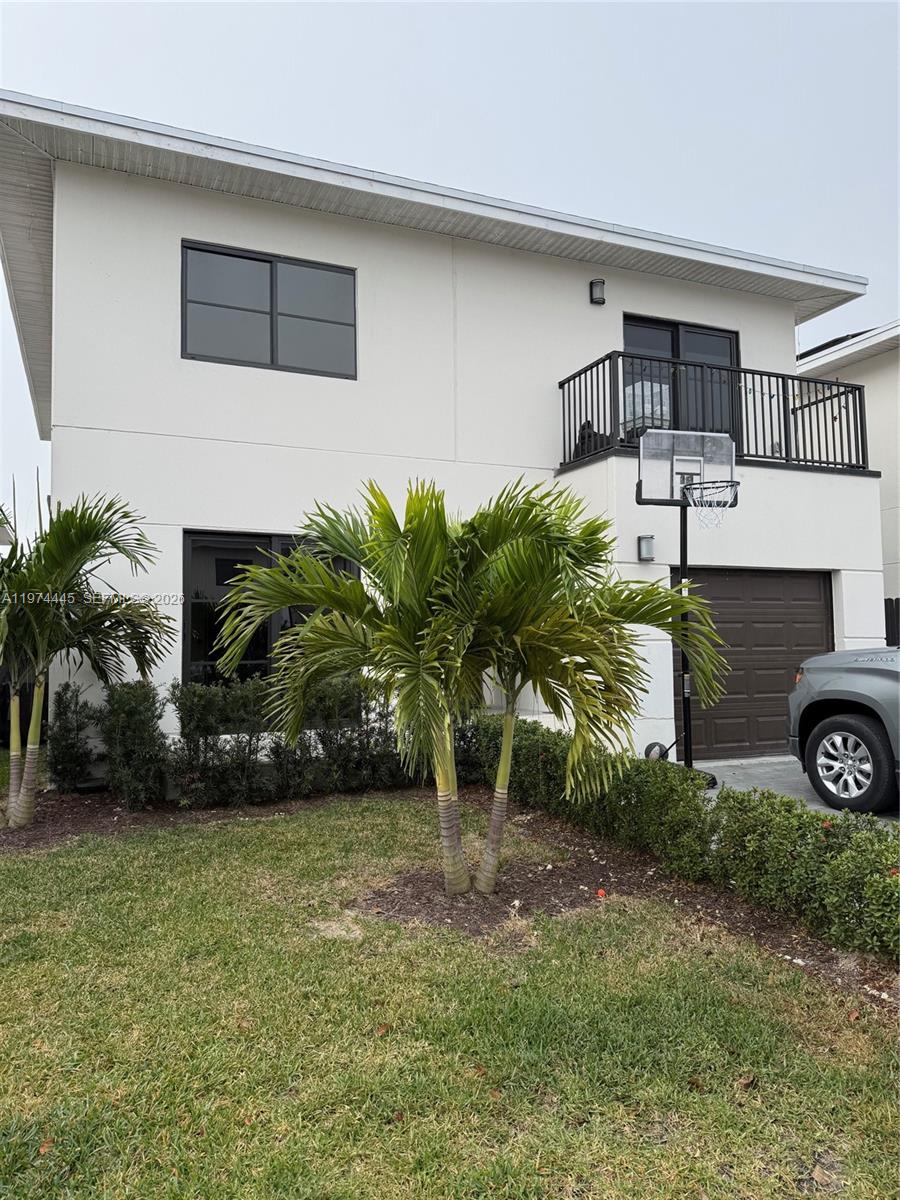 A two-story white house with a brown garage door, a balcony, and palm trees — 1360 NW 3rd St, Florida City FL 33034, FLORIDA CITY, FL