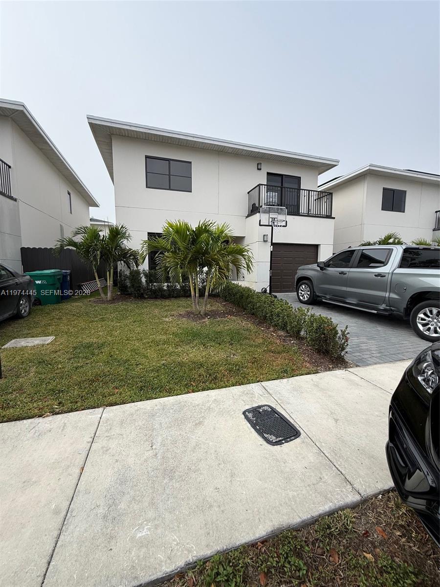 A two-story house with a paved driveway, a small front lawn, and a balcony — 1360 NW 3rd St, Florida City FL 33034, FLORIDA CITY, FL