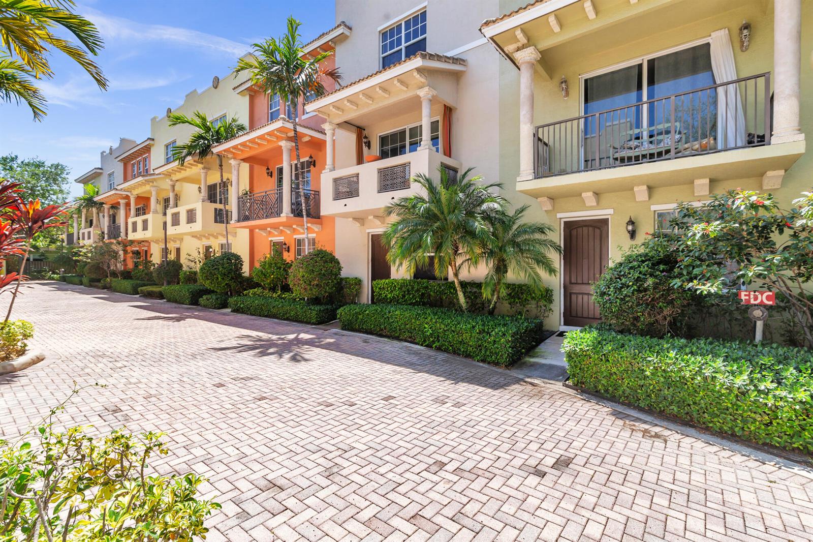 A row of multi-story townhouses with balconies and a brick-paved driveway under a blue sky — 219 N L Street # 111, FL 33460, FL