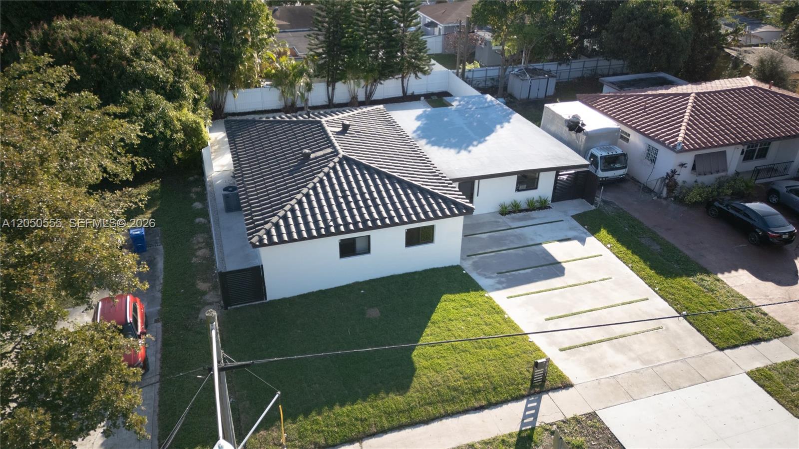 An aerial view shows a white house with a dark tiled roof and concrete driveway — 15411 NE 10th Ave, North Miami Beach FL 33162, NORTH MIAMI BEACH, FL