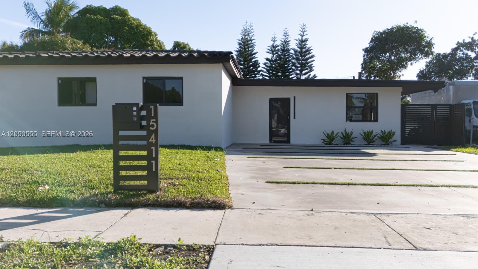 A single-story house with a white exterior, a modern mailbox, and a concrete driveway — 15411 NE 10th Ave, North Miami Beach FL 33162, NORTH MIAMI BEACH, FL