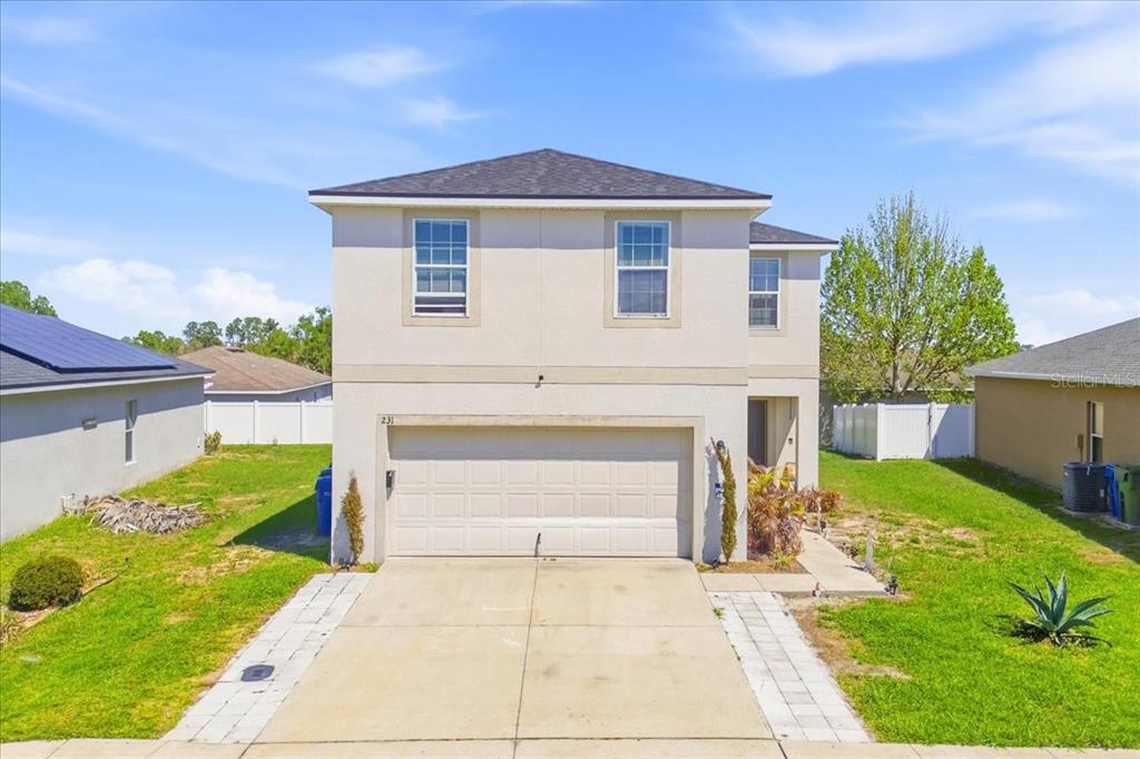 A two-story house with a beige stucco exterior, a two-car garage, and a concrete driveway — 231 HAINES BOULEVARD, WINTER HAVEN, FL