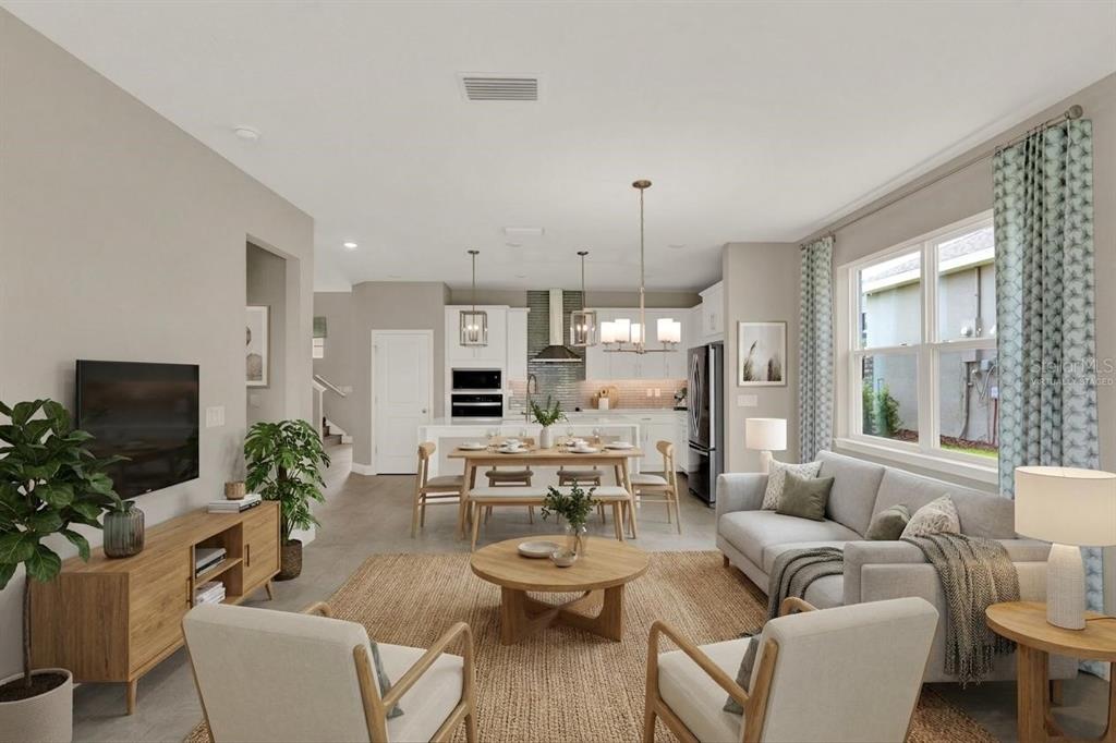 An open-concept living and dining area with a kitchen, neutral walls, and light wood furniture — 2063 KEYSTONE PASS BOULEVARD, MINNEOLA, FL
