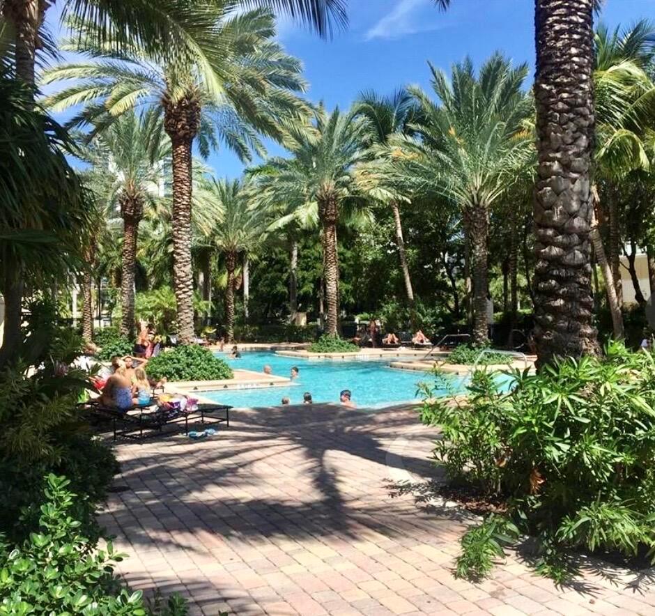 A swimming pool surrounded by palm trees and a paved patio area — 17100 N Bay Road # 1911, Sunny Isles Beach FL 33160, SUNNY ISLES BEACH, FL