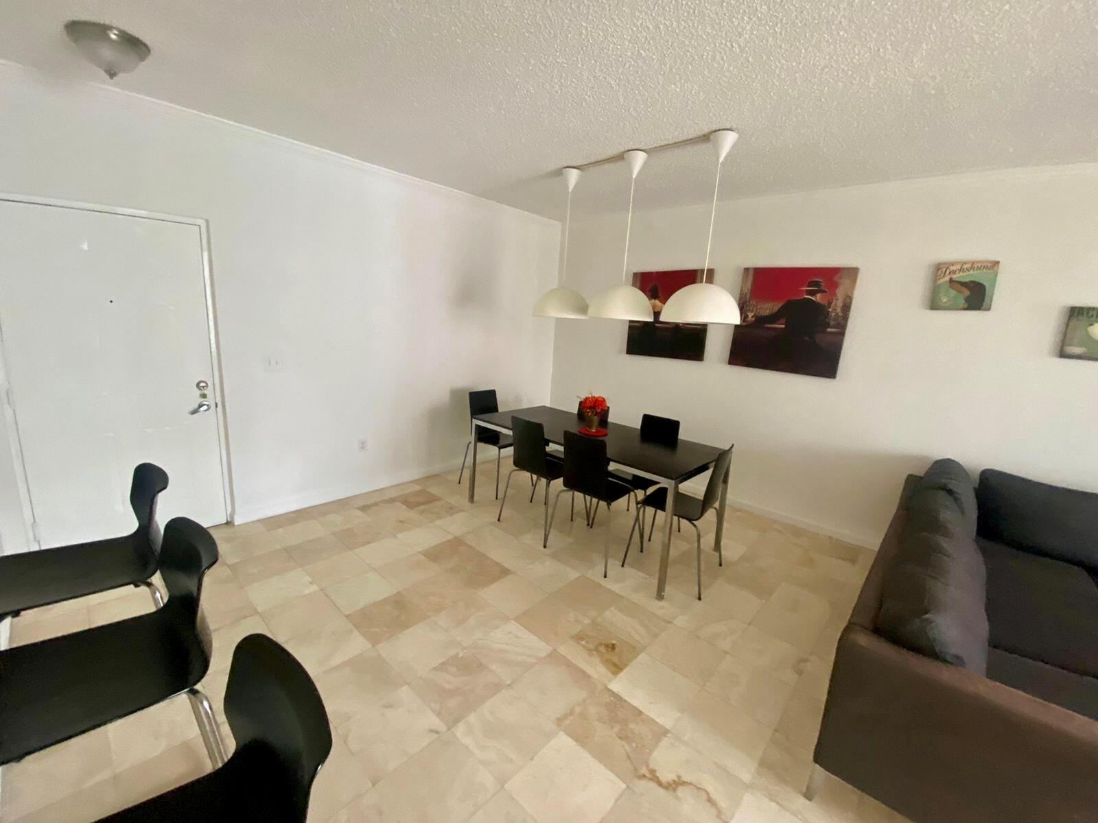 A dining area with a dark table, six black chairs, and three pendant lights — 17100 N Bay Road # 1911, Sunny Isles Beach FL 33160, SUNNY ISLES BEACH, FL