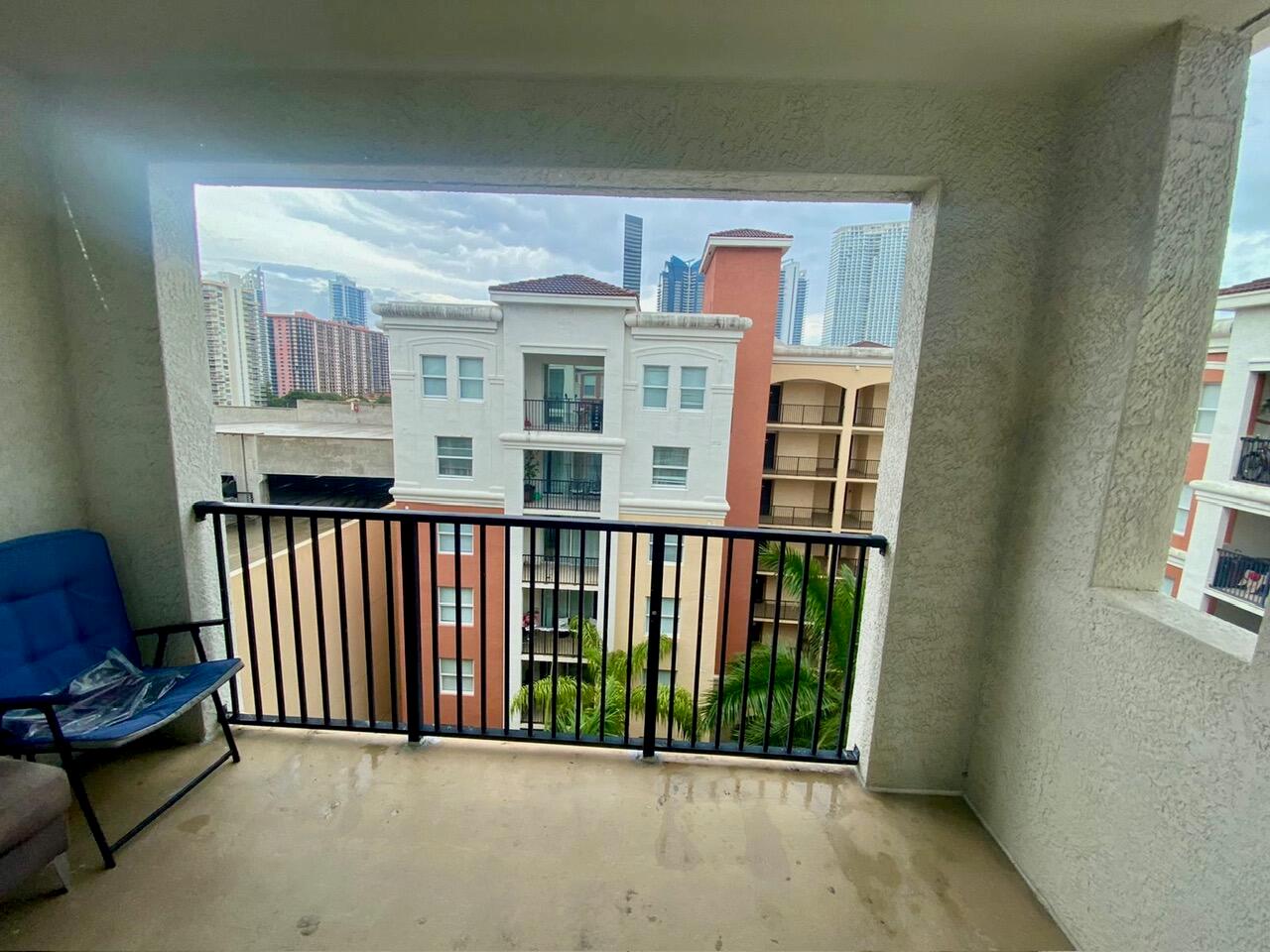 A view of neighboring apartment buildings from a covered balcony with a black metal railing — 17100 N Bay Road # 1911, Sunny Isles Beach FL 33160, SUNNY ISLES BEACH, FL