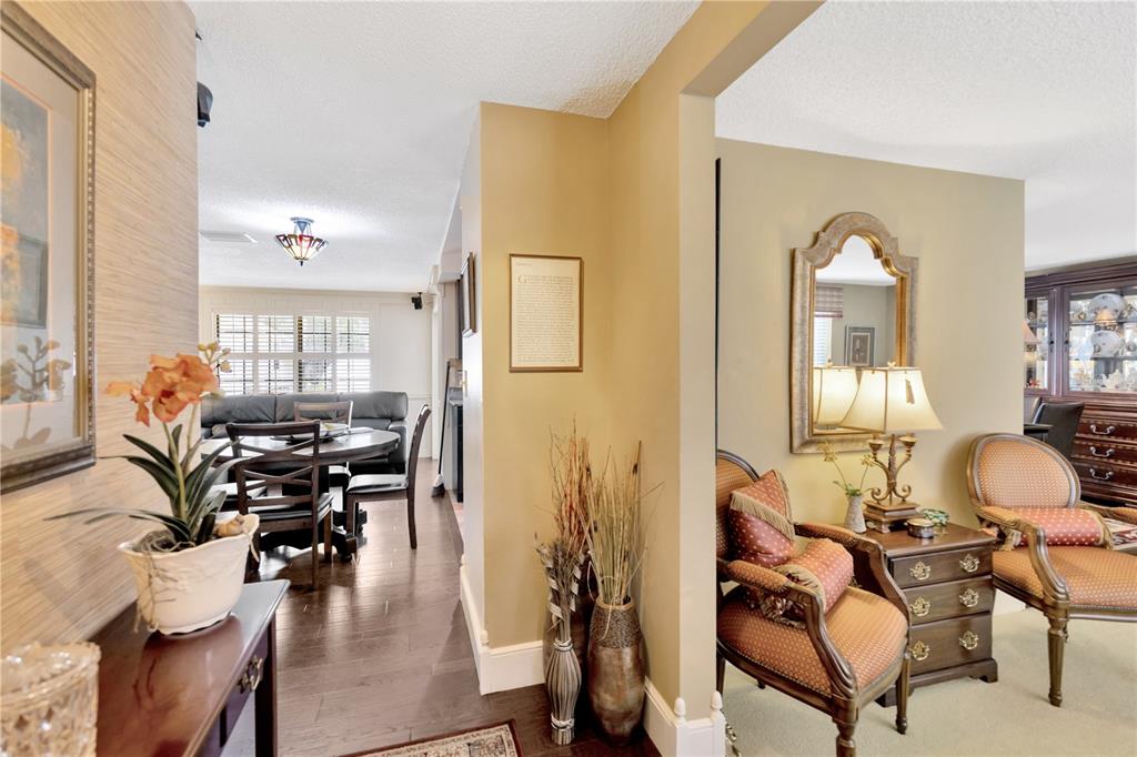 A foyer leads to a dining area with dark wood floors and a sitting room — 4909 S ELBERON STREET, TAMPA, FL