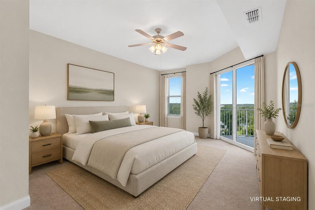 A bedroom with a king bed, ceiling fan, and sliding glass doors leading to a balcony — 2801 S RIDGEWOOD AVENUE UNIT 504, SOUTH DAYTONA, FL