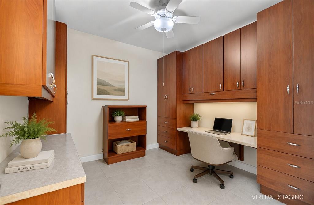 A home office features wood cabinetry, a built-in desk, tile flooring, and a ceiling fan — 2801 S RIDGEWOOD AVENUE UNIT 504, SOUTH DAYTONA, FL