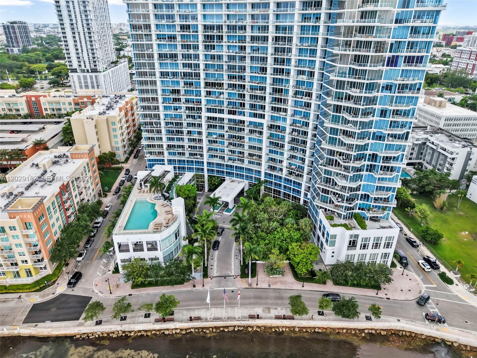 An aerial view shows a high-rise residential building with a pool deck and surrounding landscaping — 2020 N Bayshore Dr # 2603, Miami FL 33137, MIAMI, FL