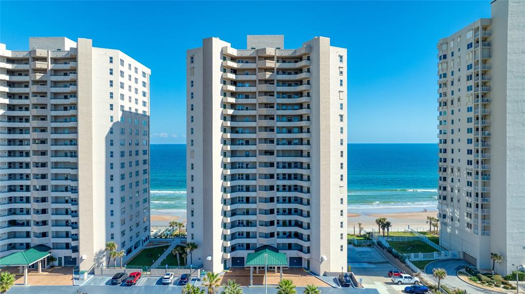 Three tall residential buildings stand along a sandy beach overlooking the ocean — 3315 S ATLANTIC AVENUE UNIT 705, DAYTONA BEACH, FL