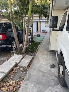 A narrow concrete driveway sits between a black car and a white recreational vehicle — 6034 Fillmore St, Hollywood FL 33024, HOLLYWOOD, FL