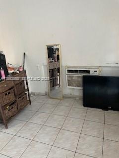 A room with tiled floors, a wooden storage unit, a floor mirror, and a window air conditioner — 6034 Fillmore St, Hollywood FL 33024, HOLLYWOOD, FL