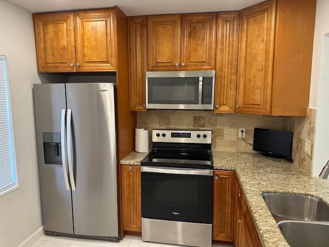 A kitchen features wood cabinets, stainless steel appliances, and granite countertops — 7605 NW 5th Court NW # 208, Margate FL 33063, MARGATE, FL