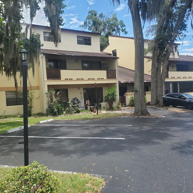 A multi-story apartment building with balconies and a parking lot in front — 3525 E FORT KING STREET UNIT 244, OCALA, FL