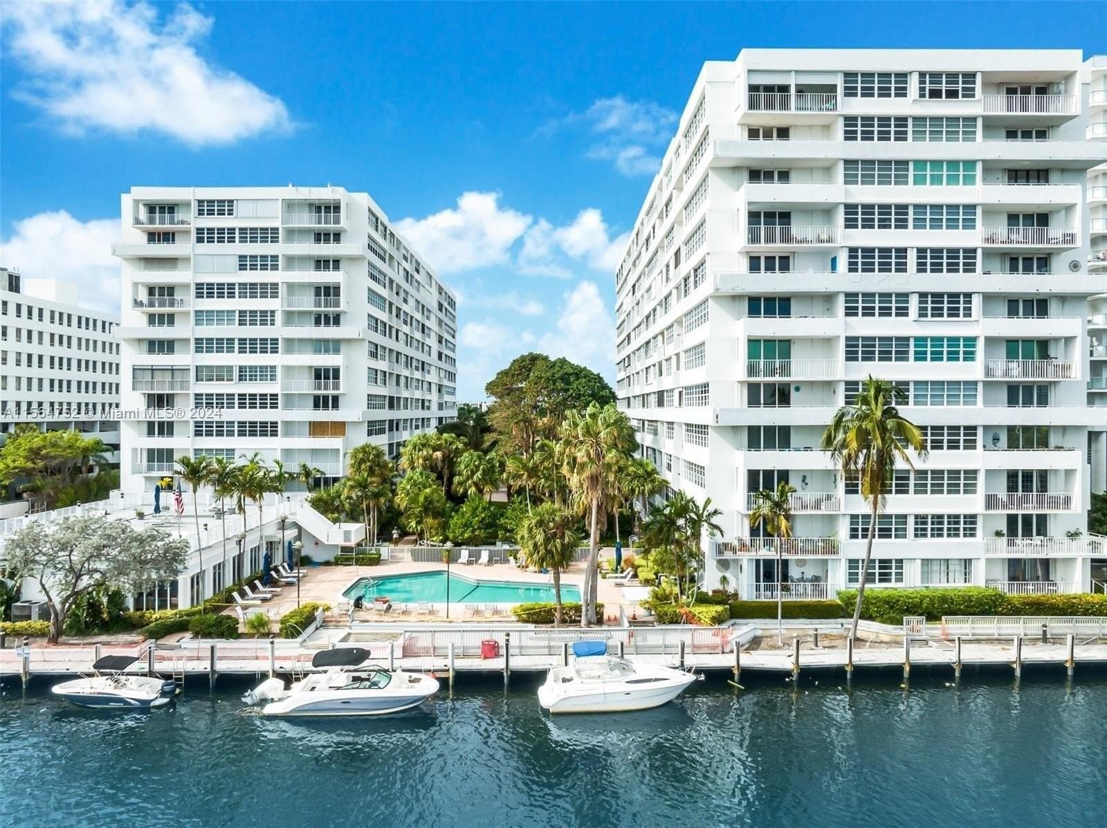 An aerial view shows two white apartment buildings flanking a swimming pool and boat docks — 1160 N Federal Highway # 1118, Fort Lauderdale FL 33304, FORT LAUDERDALE, FL