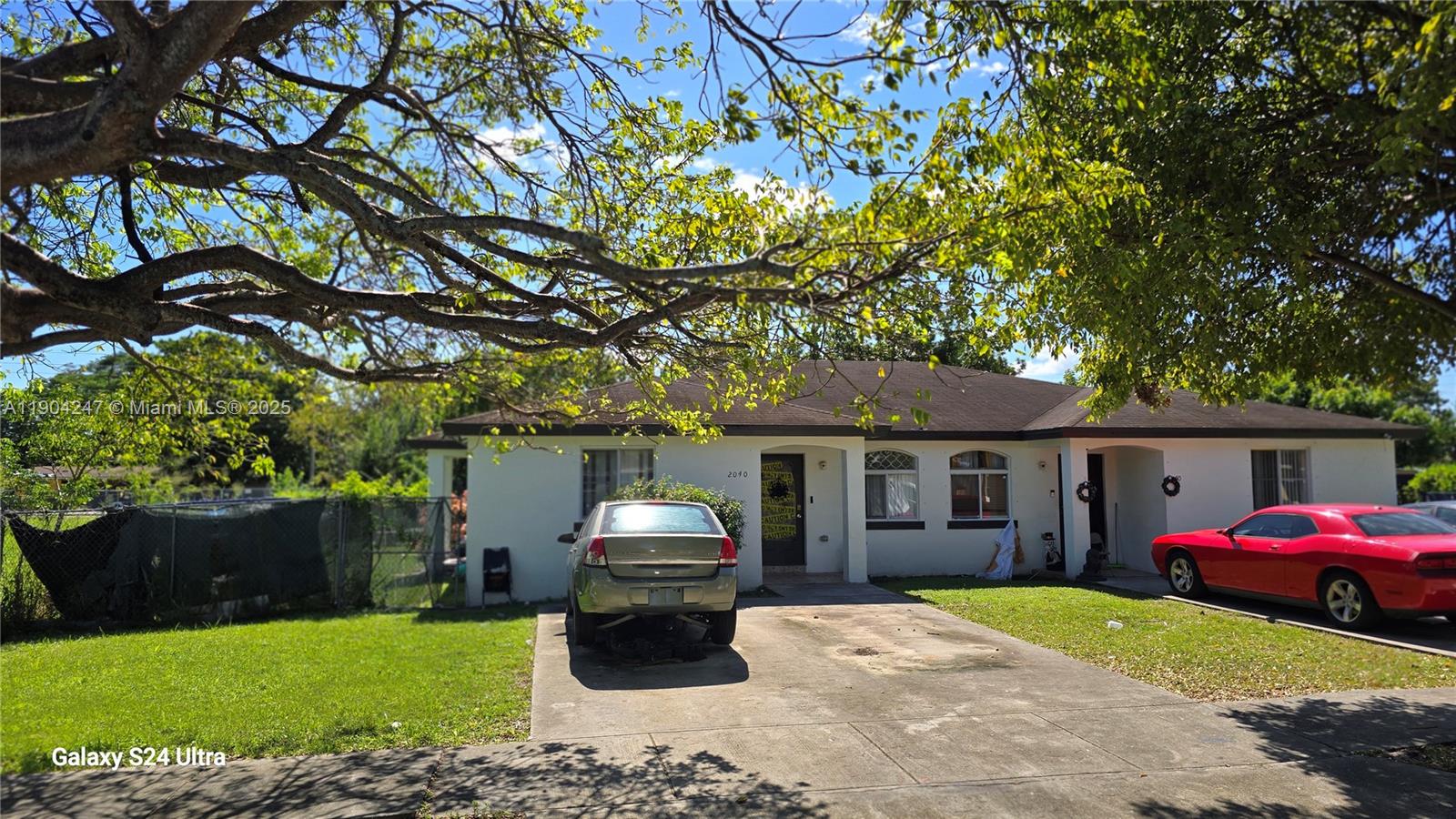 A single-story house with a concrete driveway, a parked silver sedan, and a red coupe — 12040 SW 215th St, Miami FL 33177, MIAMI, FL