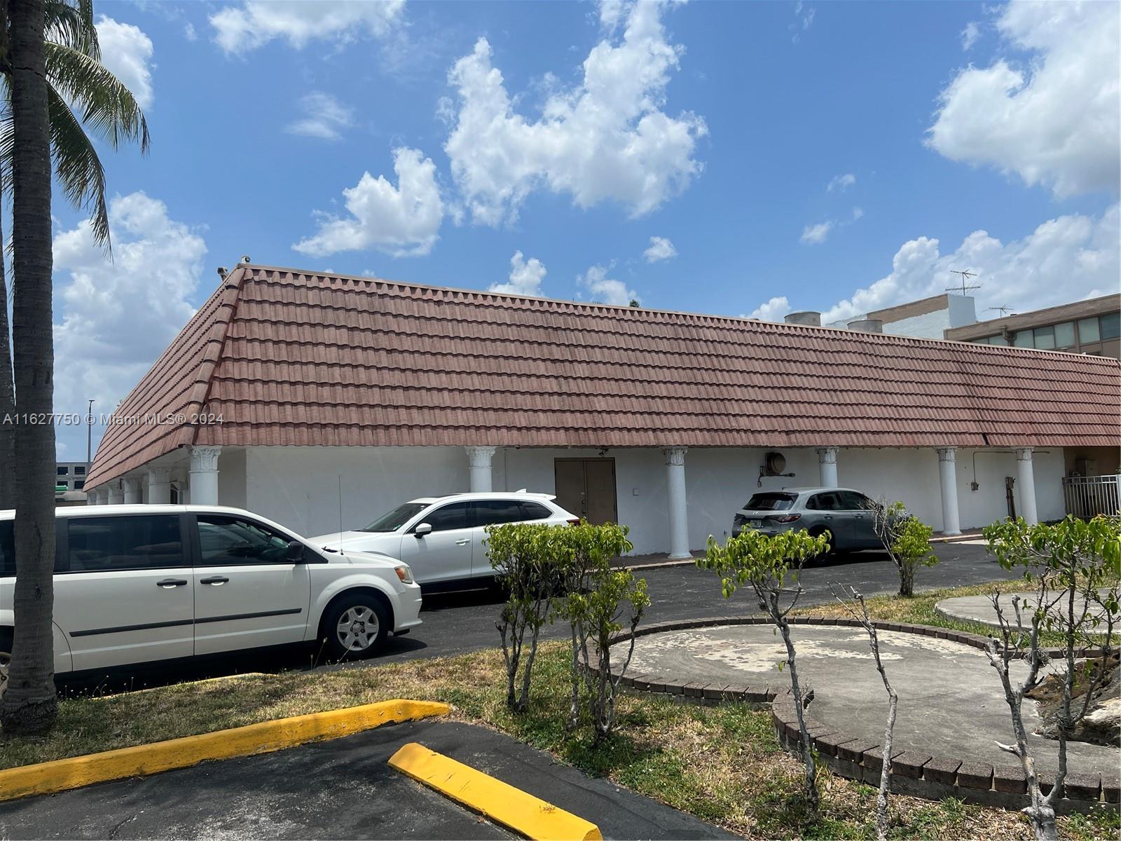 A white building with a brown tiled roof and columns sits behind a parking lot — 16805 NW 12th Ave, Miami Gardens FL 33169, MIAMI GARDENS, FL