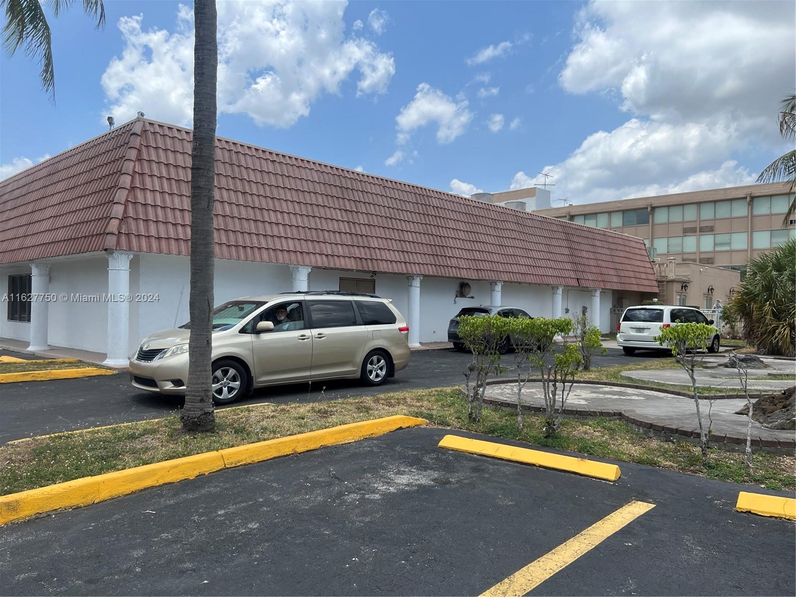 A single-story building with a red tile roof and white columns sits behind a parking lot — 16805 NW 12th Ave, Miami Gardens FL 33169, MIAMI GARDENS, FL