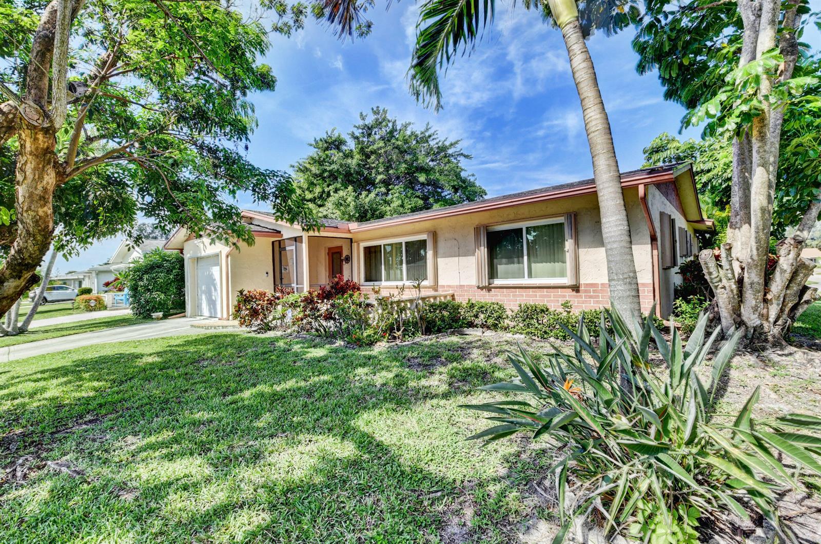 A single-story house with a tan stucco exterior, brick accents, and a front-facing garage — 14425 Amapola Way, Delray Beach FL 33484, DELRAY BEACH, FL