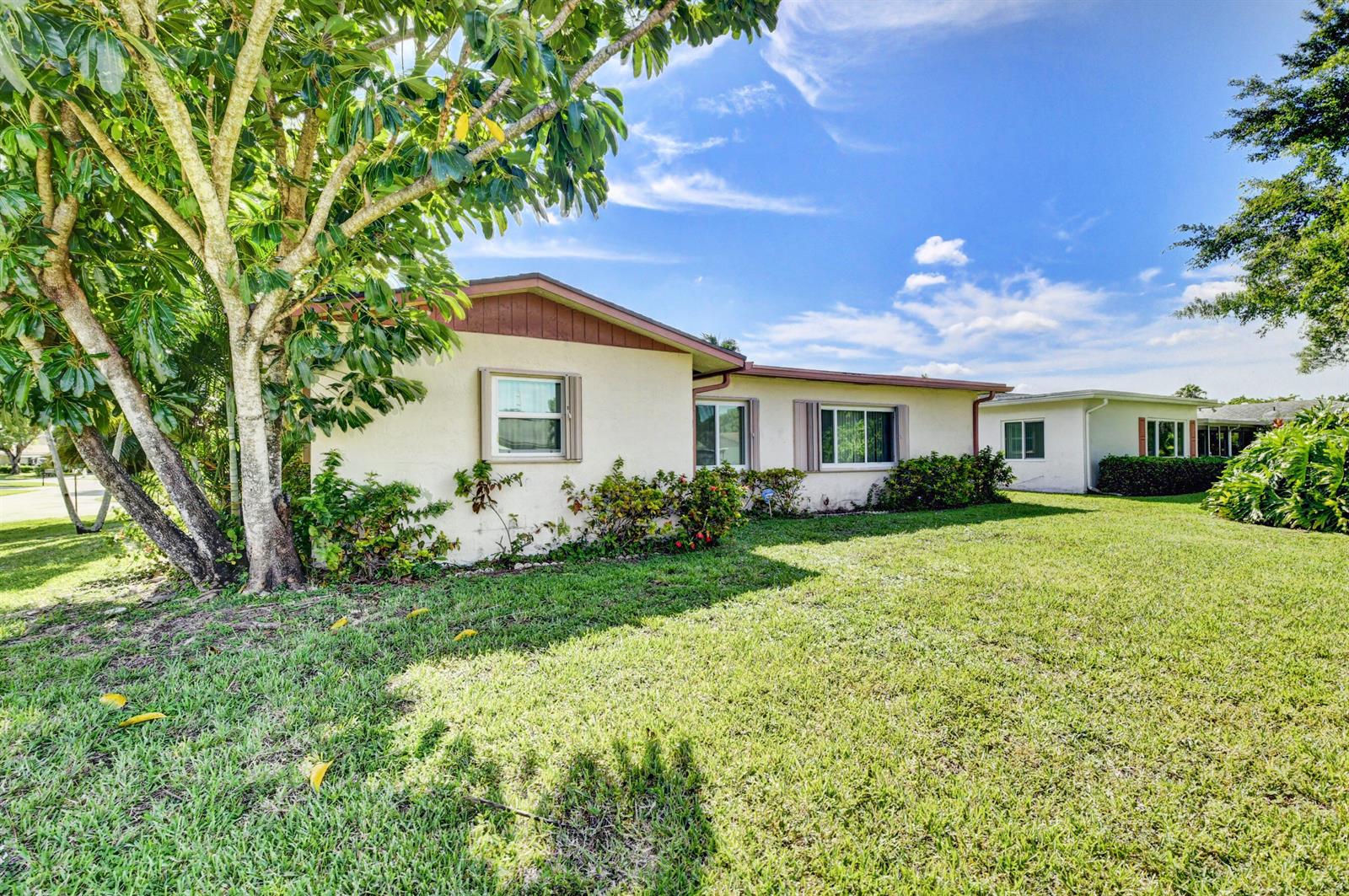 A single-story house with a beige stucco exterior and a large tree in the yard — 14425 Amapola Way, Delray Beach FL 33484, DELRAY BEACH, FL
