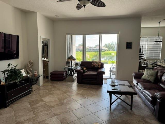 A living room features tile floors, a ceiling fan, a leather sofa, and sliding glass doors — 6145 E 41 STREET, BRADENTON, FL