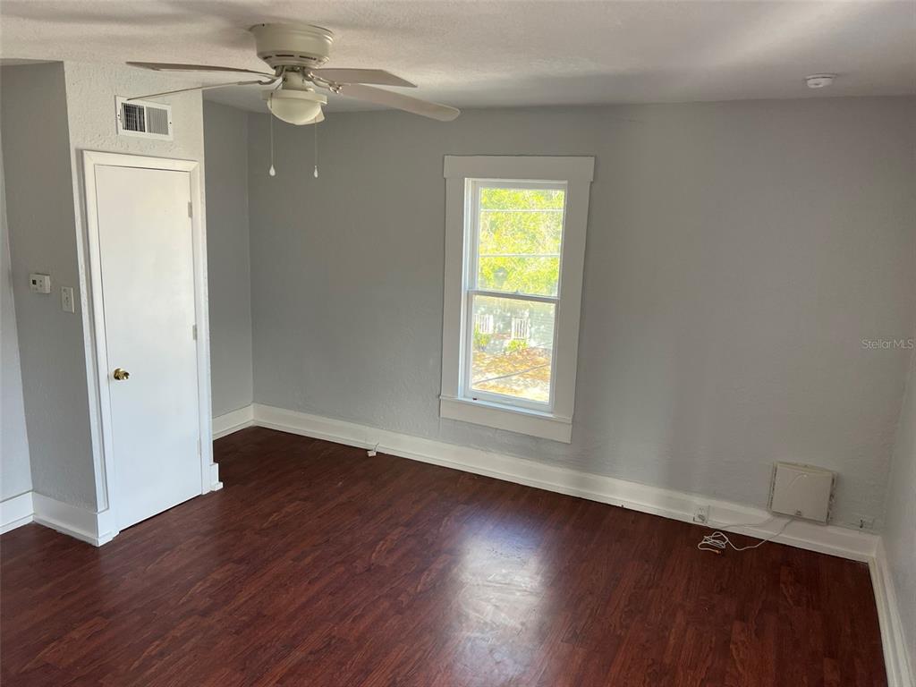 A bedroom with gray walls, wood-look flooring, a ceiling fan, and a single window — 901 PENNSYLVANIA AVENUE UNIT 4, LAKELAND, FL