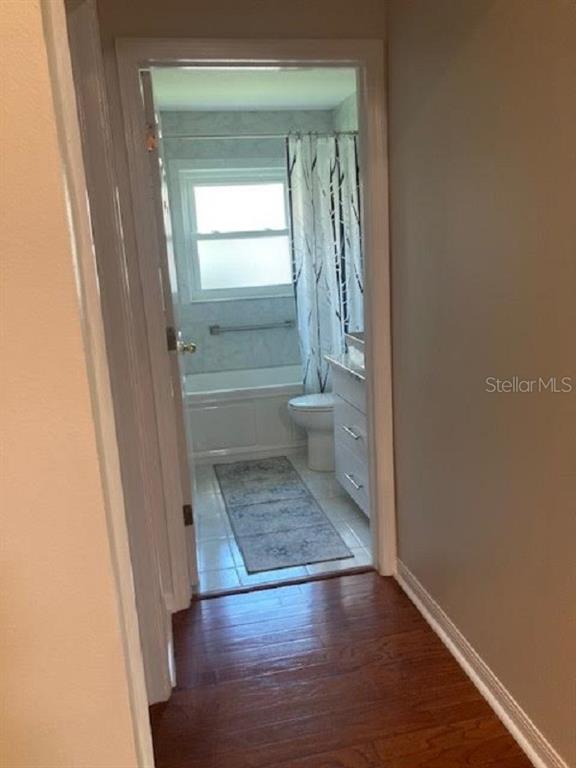 A view from a hallway into a bathroom with a tub, shower, and vanity — 10007 BROOKDALE DRIVE, NEW PORT RICHEY, FL