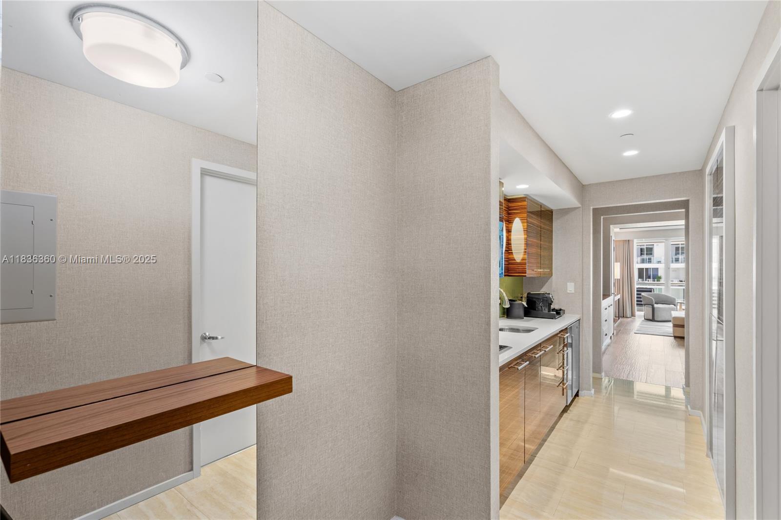 A hallway features a floating wooden shelf, a small kitchenette, and a view into a living area — 551 N Fort Lauderdale Beach Blvd # R1909, Fort Lauderdale FL 33304, FORT LAUDERDALE, FL