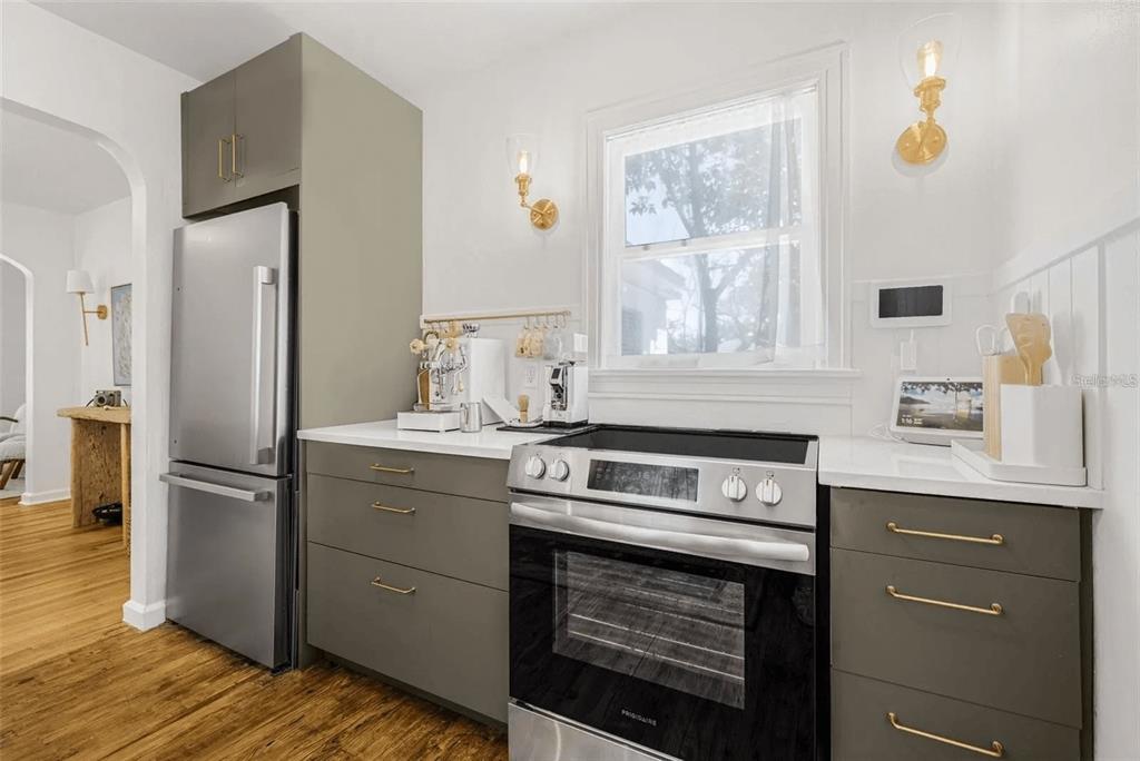A kitchen features gray flat-panel cabinets, stainless steel appliances, white countertops, and gold hardware — 3500 6TH AVENUE N, ST PETERSBURG, FL