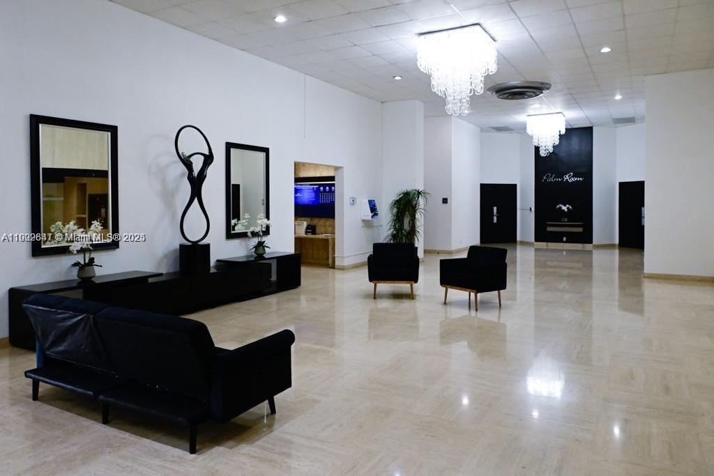 A spacious lobby features black furniture, two crystal chandeliers, and a designated Palm Room entrance — 500 Three Islands Blvd # 908, Hallandale Beach FL 33009, HALLANDALE BEACH, FL