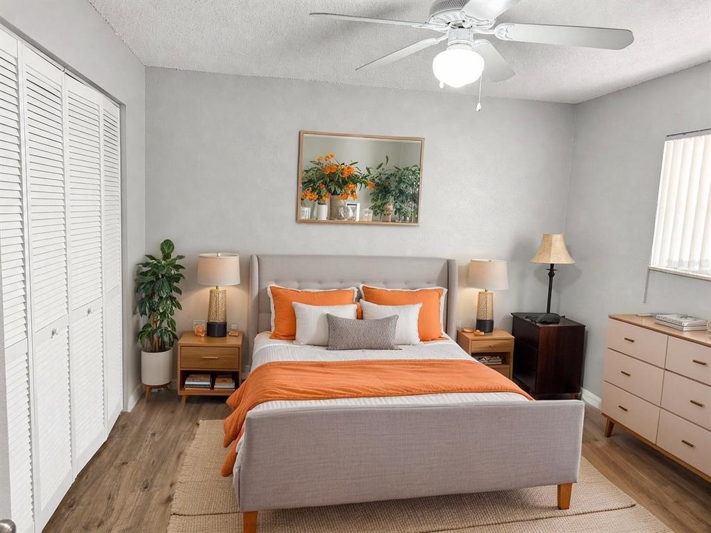 A bedroom features a gray upholstered bed, orange bedding, two nightstands, and a white dresser — 2811 SW ARCHER ROAD UNIT P134, GAINESVILLE, FL