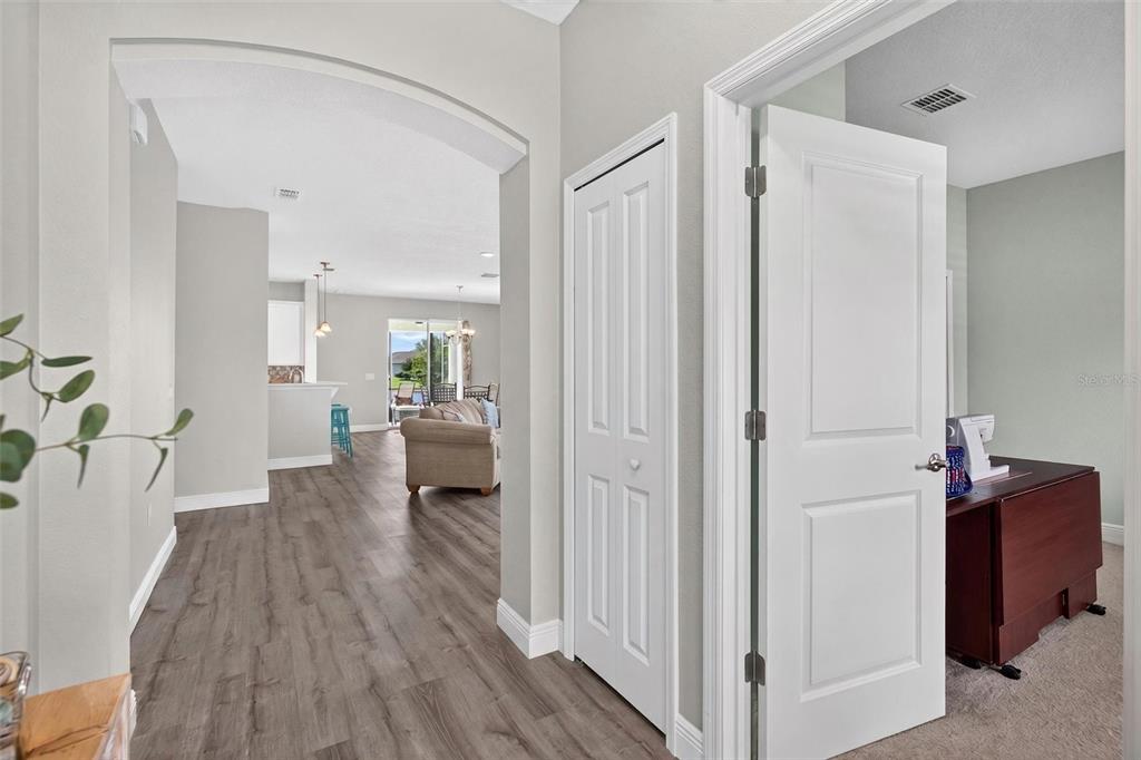 A hallway with wood-look flooring leads to an open living area and kitchen — 55 HUNTINGTON PLACE, ORMOND BEACH, FL