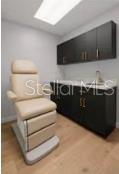 A medical exam room features a beige treatment chair, dark cabinetry, and light wood flooring — 2511 W MLK BOULEVARD, TAMPA, FL
