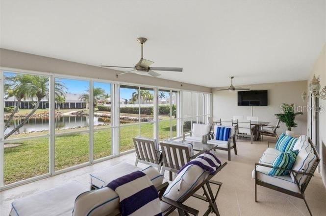 A screened-in patio features outdoor furniture, ceiling fans, and a view of a pond — 2521 W MARION AVENUE UNIT 311, PUNTA GORDA, FL