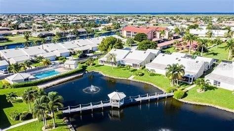 An aerial view shows a pond with a fountain and gazebo surrounded by residential buildings — 2521 W MARION AVENUE UNIT 311, PUNTA GORDA, FL