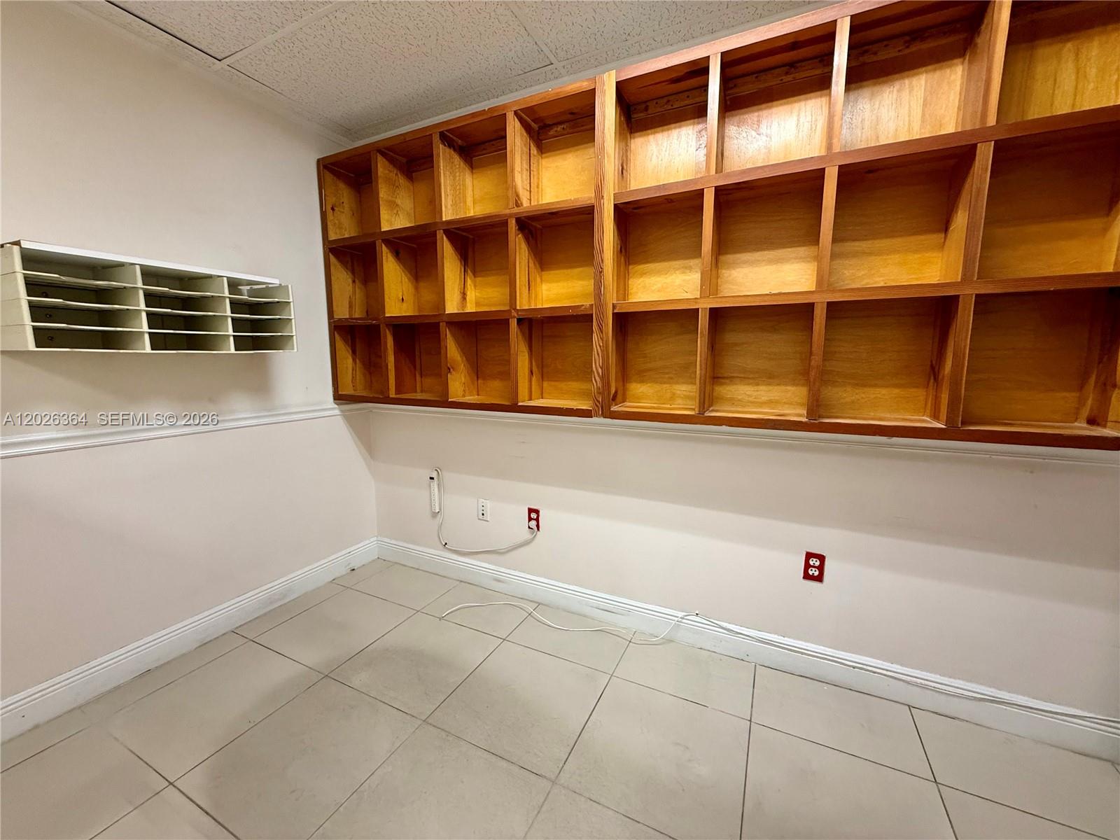 A room features tiled floors, a white wall-mounted mail sorter, and large wooden cubby shelves — 8370 W Flagler St # 120, Miami FL 33144, MIAMI, FL