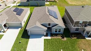 An aerial view of three suburban houses with gray roofs and solar panels — 1163 JAMES PAUL ROAD, DAVENPORT, FL