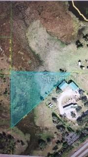 This is an aerial map showing a triangular parcel of land highlighted in blue — 0 LAKE MILLSITE RD E, WINTER HAVEN, FL
