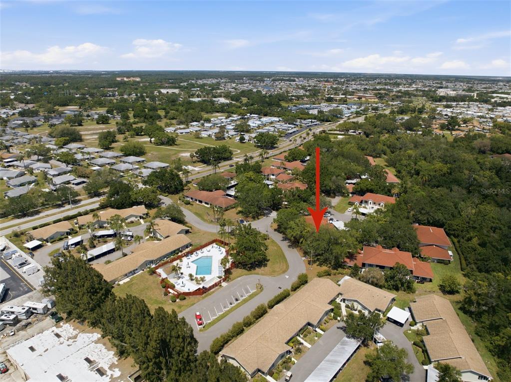 An aerial view shows a residential community with a swimming pool and surrounding buildings — 309 KNOTTWOOD COURT UNIT 309, SUN CITY CENTER, FL