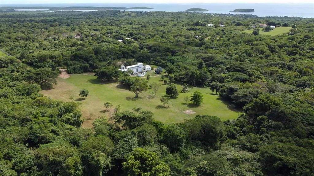 An aerial view shows a white house situated on a large, grassy, tree-lined lot — 37 HIDEAWAY LANE, VIEQUES, PR