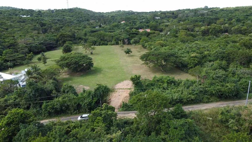 An aerial view shows a cleared grassy lot surrounded by dense trees and vegetation — 37 HIDEAWAY LANE, VIEQUES, PR