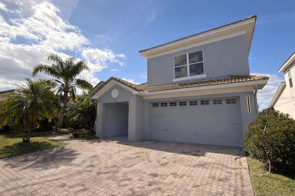 A two-story gray house with a tiled roof, a two-car garage, and a paved driveway — 3504 VALLEYVIEW DRIVE, KISSIMMEE, FL