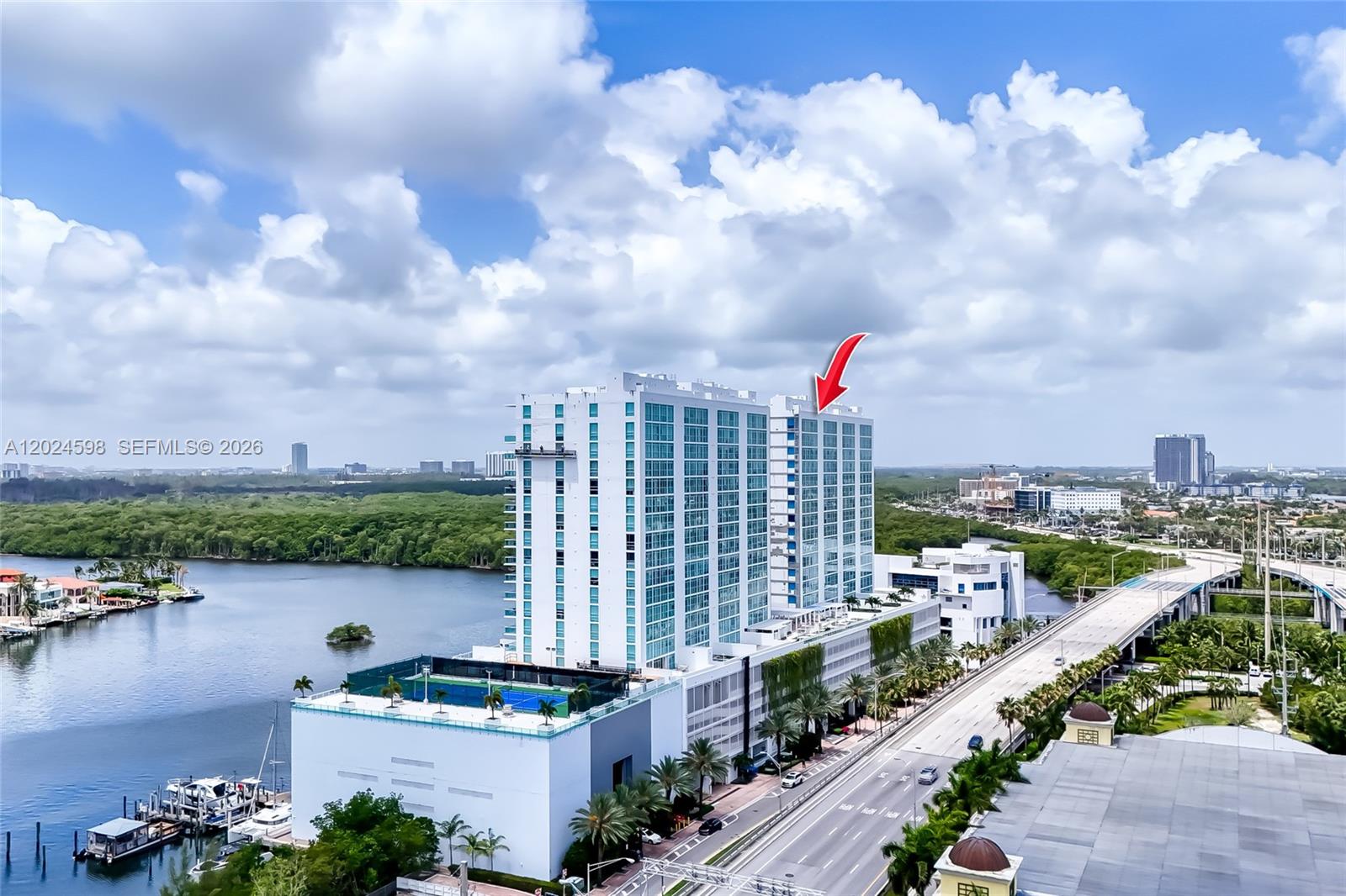 An aerial view shows a tall, modern residential building with a red arrow pointing toward the top floors — 400 Sunny Isles Blvd # 1202, Sunny Isles Beach FL 33160, SUNNY ISLES BEACH, FL